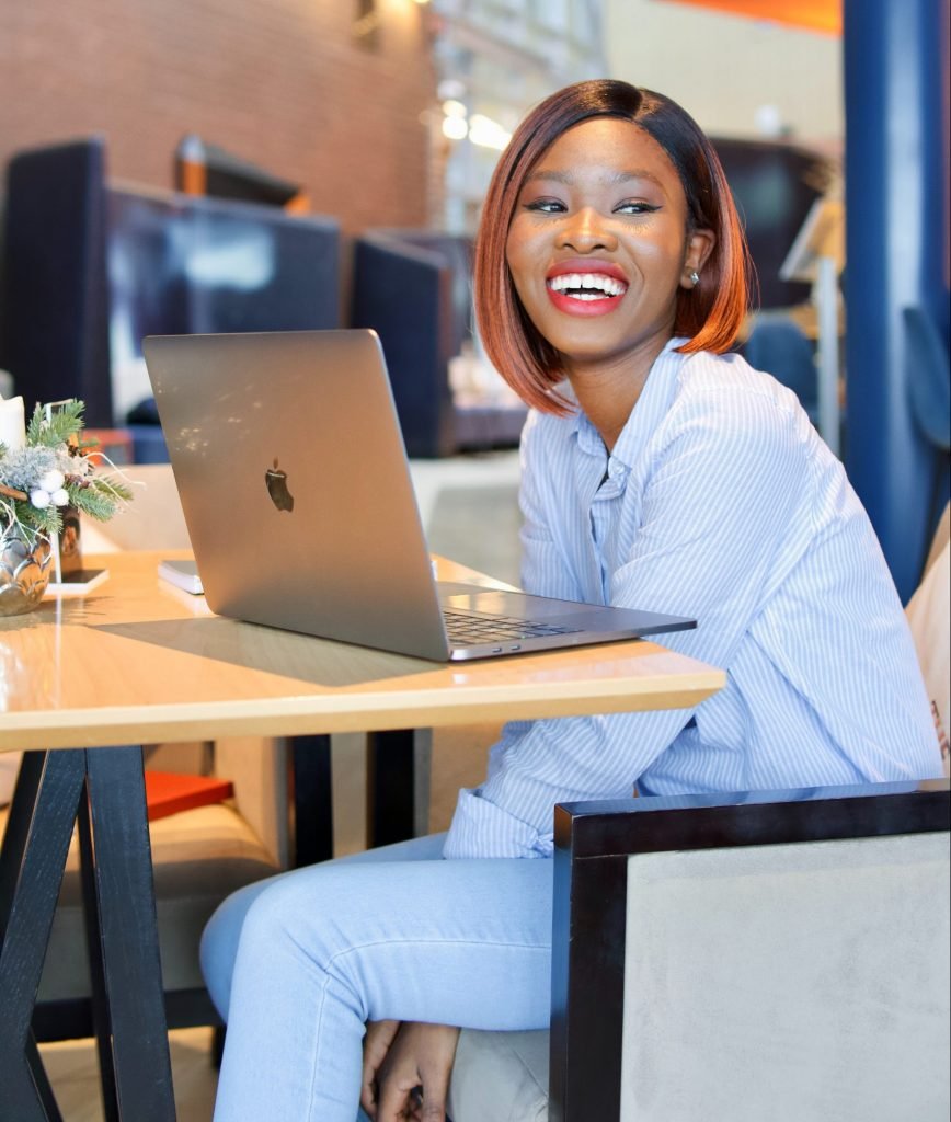 A smiling black lady at a coffee shop on a work lunch break